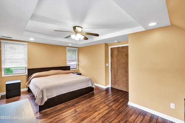 bedroom featuring a raised ceiling, baseboards, wood finished floors, recessed lighting, and ceiling fan