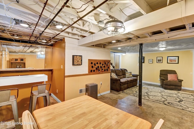 below grade area featuring baseboards and a dry bar