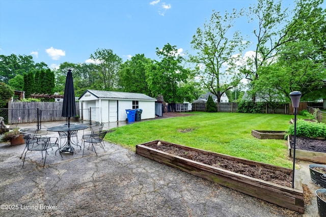 view of yard featuring a garden, an outdoor structure, a patio, and outdoor dining space