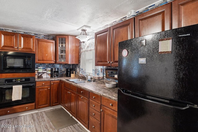 271 Carters St, New Castle, KY 40050 - kitchen with black appliances, a sink, a textured ceiling, light wood-style flooring, and brown cabinets