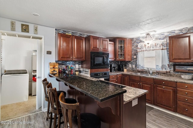 271 Carters St, New Castle, KY 40050 - kitchen featuring black appliances, a sink, a textured ceiling, light wood-style floors, and a kitchen bar