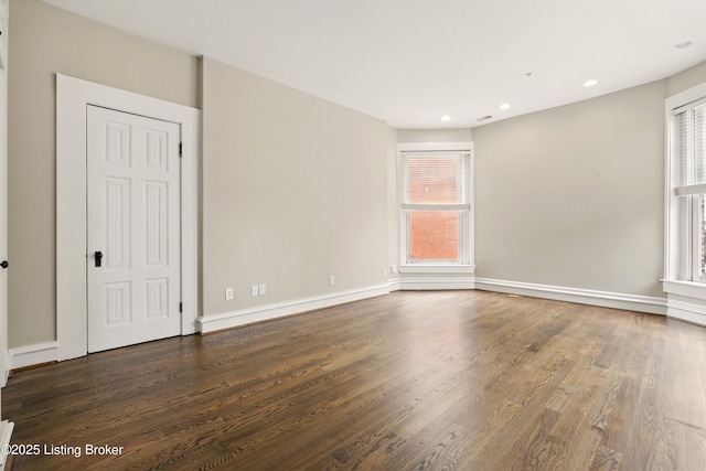 unfurnished room featuring wood finished floors, recessed lighting, and baseboards