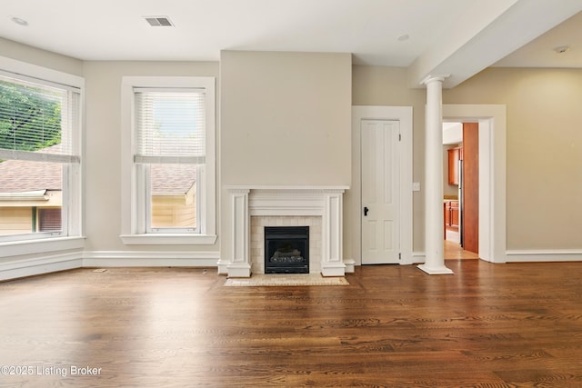 unfurnished living room with wood finished floors, baseboards, and a fireplace with flush hearth