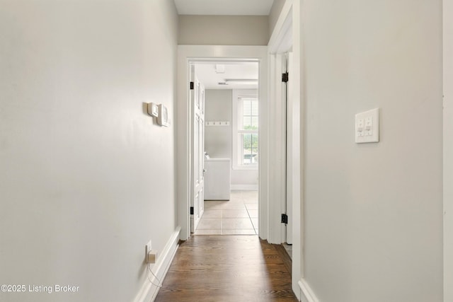 hall with baseboards and wood finished floors