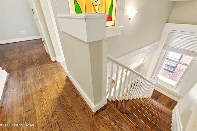 staircase with wood finished floors and baseboards