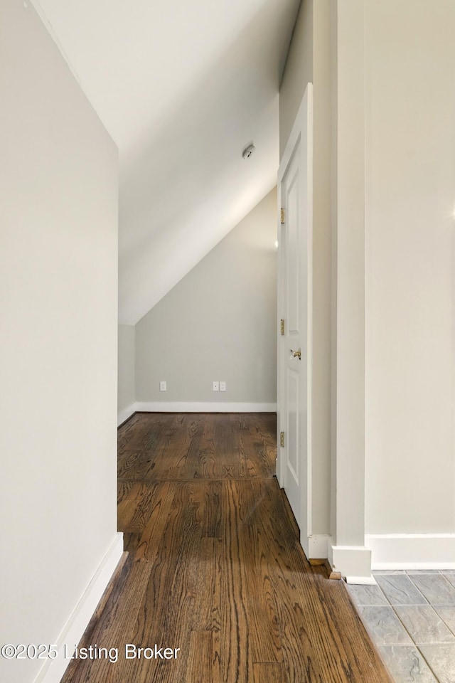 additional living space with vaulted ceiling, baseboards, and wood finished floors