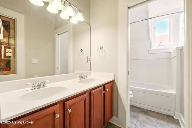 full bathroom with toilet, double vanity, and stone finish flooring