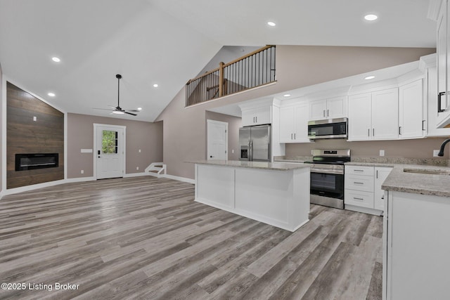 314 Nolin Estates Rd, Clarkson, KY 42726 - kitchen with stainless steel appliances, a sink, open floor plan, a fireplace, and a center island