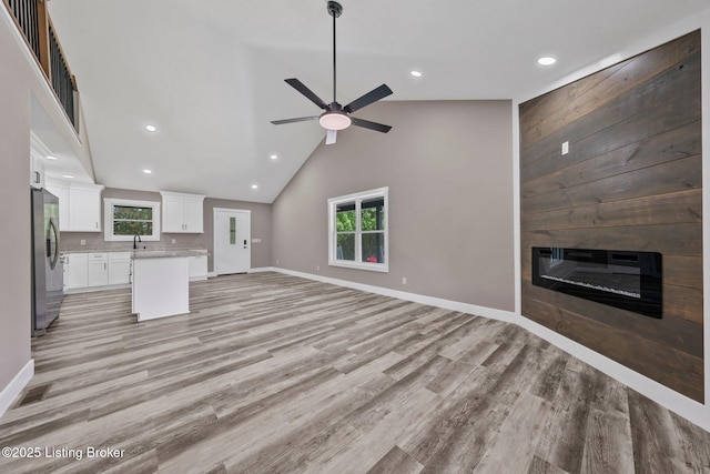 314 Nolin Estates Rd, Clarkson, KY 42726 - unfurnished living room featuring light wood-style floors, recessed lighting, a ceiling fan, a large fireplace, and a sink