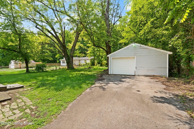 6614 Putman St, Louisville, KY 40216 - view of green lawn featuring an outbuilding, a detached garage, and asphalt driveway