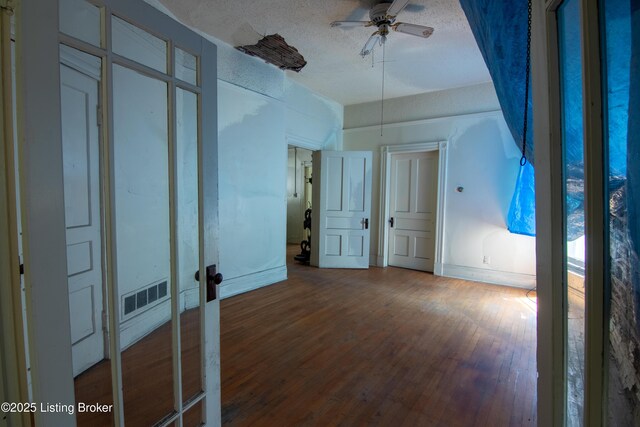 2511 W Chestnut St, Louisville, KY 40211 - unfurnished bedroom with wood finished floors, baseboards, french doors, and a textured ceiling