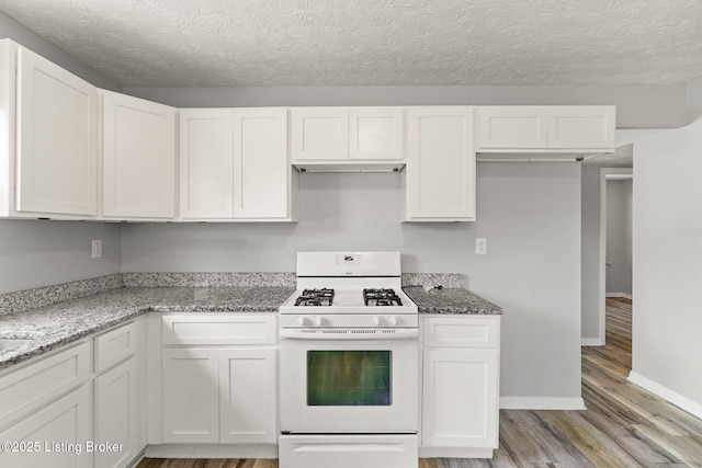1037 Kaiser Ct, Louisville, KY 40211 - kitchen with white gas range oven, light wood-style flooring, white cabinets, light stone countertops, and a textured ceiling
