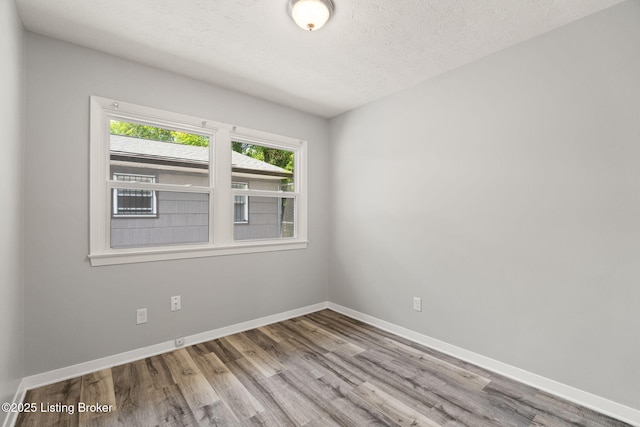1037 Kaiser Ct, Louisville, KY 40211 - spare room featuring wood finished floors, baseboards, and a textured ceiling
