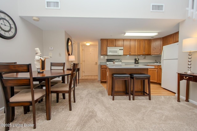 2730 Brownsboro Rd Apt 166, Louisville, KY 40206 - kitchen featuring white appliances, light colored carpet, a kitchen island, light countertops, and brown cabinets