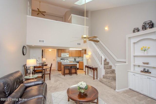 2730 Brownsboro Rd Apt 166, Louisville, KY 40206 - living area with a ceiling fan, a high ceiling, light carpet, and stairs