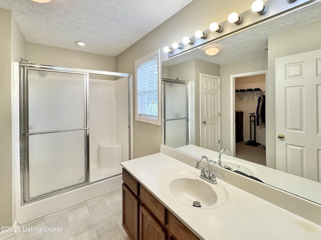 10923 Collington Dr, Louisville, KY 40241 - bathroom with a stall shower, a textured ceiling, vanity, and a walk in closet