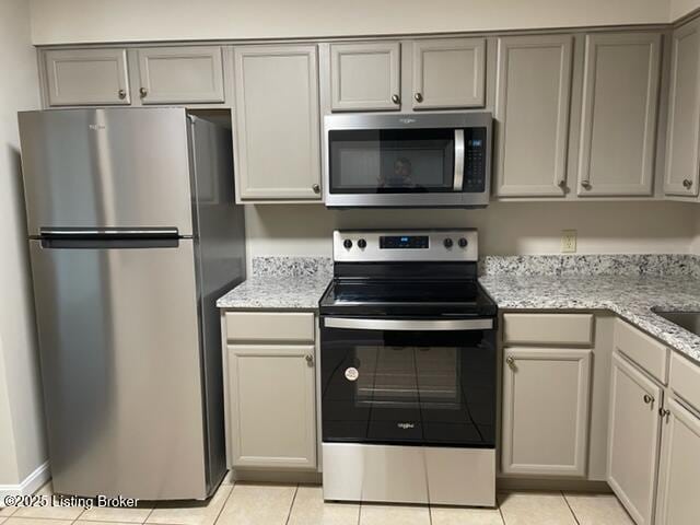 1505 La Fontenay Ct, Louisville, KY 40223 - kitchen with stainless steel appliances, light tile patterned floors, gray cabinetry, and light stone counters