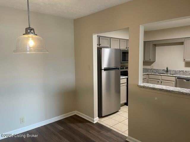 1505 La Fontenay Ct, Louisville, KY 40223 - kitchen with appliances with stainless steel finishes, a sink, gray cabinets, light stone counters, and pendant lighting