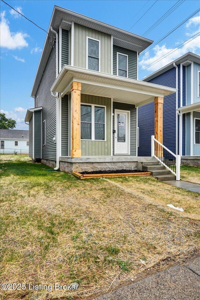 629 S 19th St, Louisville, KY 40203 - view of front facade featuring board and batten siding, a front yard, and a porch