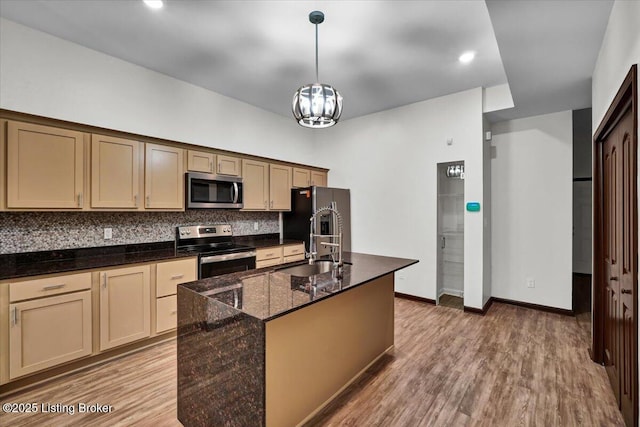 629 S 19th St, Louisville, KY 40203 - kitchen with appliances with stainless steel finishes, decorative backsplash, wood finished floors, a kitchen island with sink, and recessed lighting