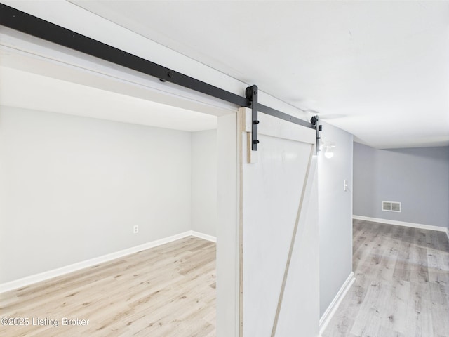 4212 David Ave, Louisville, KY 40215 - finished below grade area with light wood-style flooring, baseboards, and a barn door
