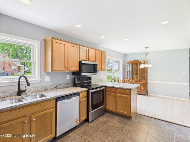 4212 David Ave, Louisville, KY 40215 - kitchen with stainless steel appliances, a sink, a peninsula, recessed lighting, and light stone countertops
