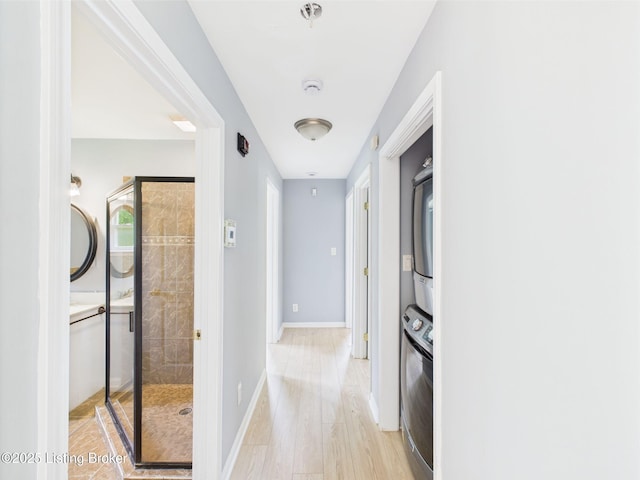 4212 David Ave, Louisville, KY 40215 - hall featuring stacked washer / drying machine, light wood finished floors, and baseboards