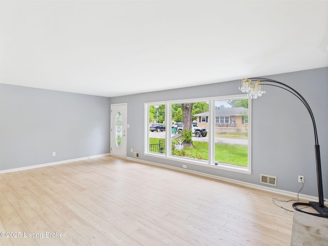 4212 David Ave, Louisville, KY 40215 - unfurnished living room with a chandelier, light wood-style flooring, and baseboards