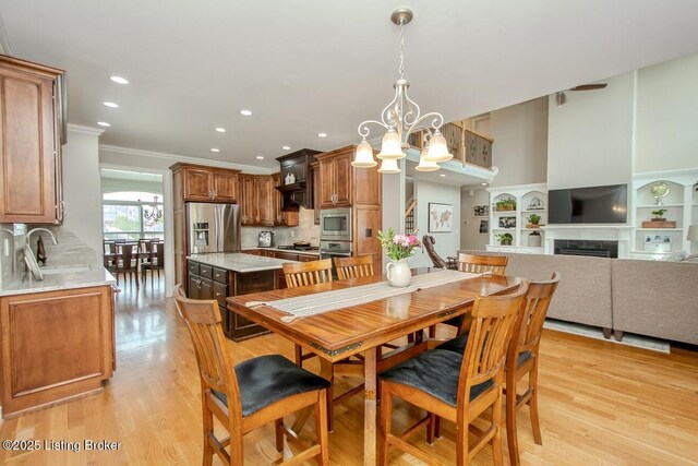 18705 Weymuth Ln, Louisville, KY 40245 - dining area with ornamental molding, a chandelier, recessed lighting, light wood-style flooring, and a fireplace