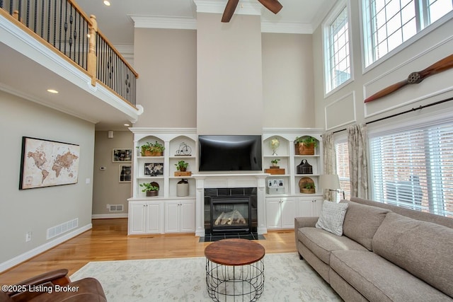 18705 Weymuth Ln, Louisville, KY 40245 - living area with a high ceiling, light wood finished floors, ceiling fan, a tile fireplace, and crown molding