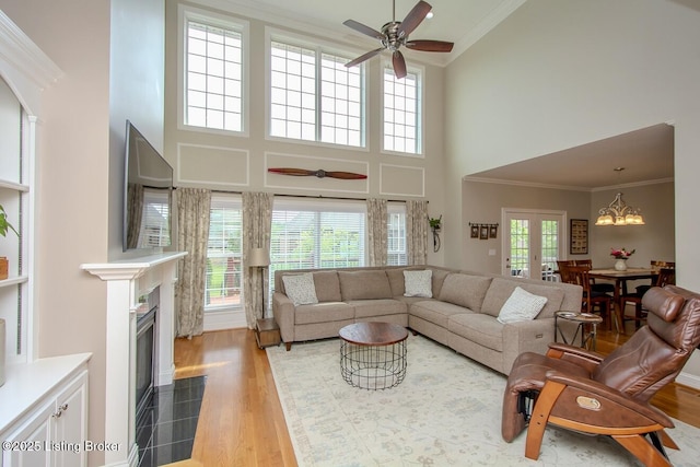 18705 Weymuth Ln, Louisville, KY 40245 - living room with a high ceiling, light wood-style flooring, a fireplace with flush hearth, ceiling fan, and ornamental molding