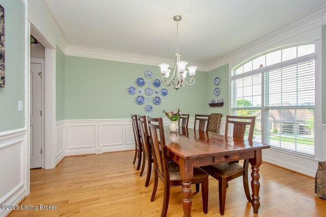 18705 Weymuth Ln, Louisville, KY 40245 - dining space featuring plenty of natural light, light wood finished floors, a chandelier, crown molding, and a wainscoted wall