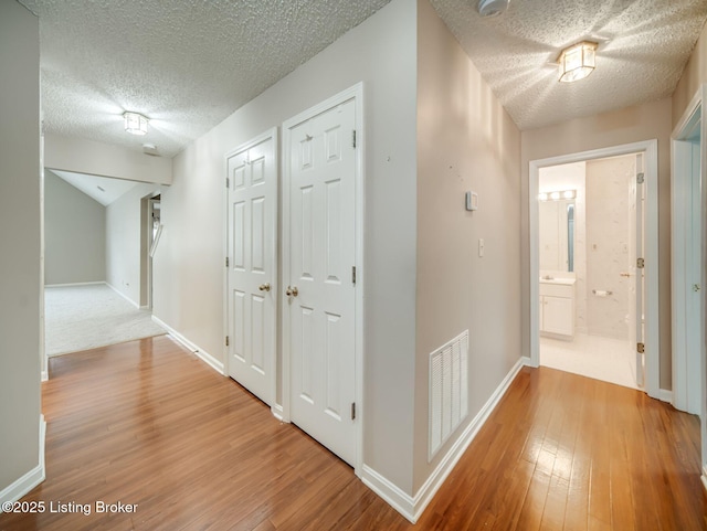 7906 Tuckaway Ct, Louisville, KY 40291 - corridor featuring wood finished floors, a textured ceiling, and baseboards