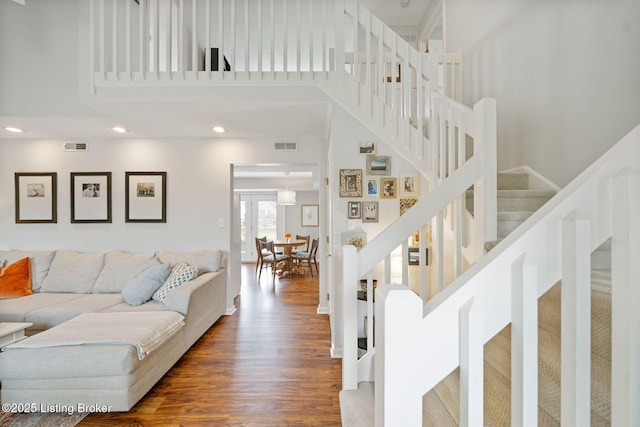 living room featuring stairway, wood finished floors, a towering ceiling, and recessed lighting
