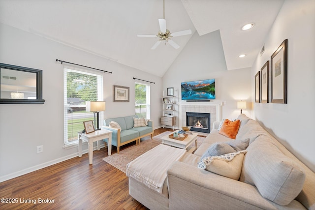 living room with wood finished floors, baseboards, high vaulted ceiling, a fireplace, and ceiling fan