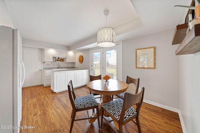 dining area featuring baseboards and light wood-style floors