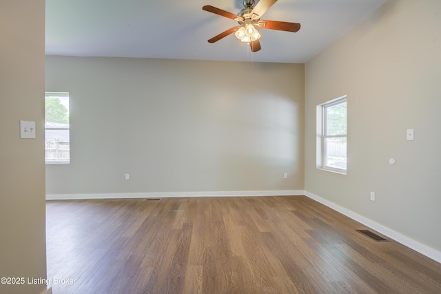 474 N 29th St, Louisville, KY 40212 - spare room featuring wood finished floors, healthy amount of natural light, a ceiling fan, and baseboards
