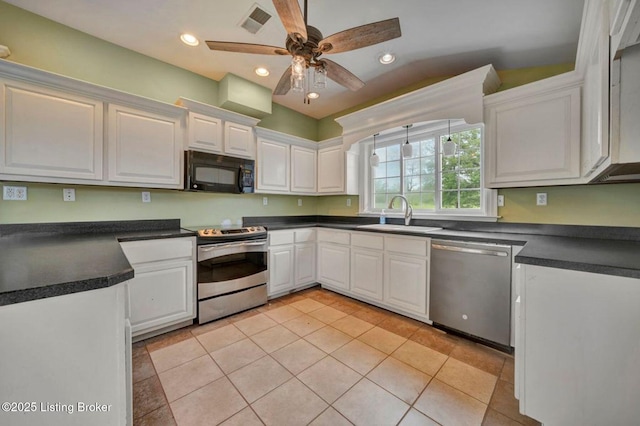 kitchen with stainless steel appliances, a sink, dark countertops, white cabinetry, and recessed lighting
