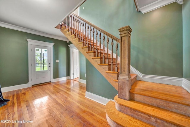 staircase with baseboards, ornamental molding, and hardwood / wood-style flooring