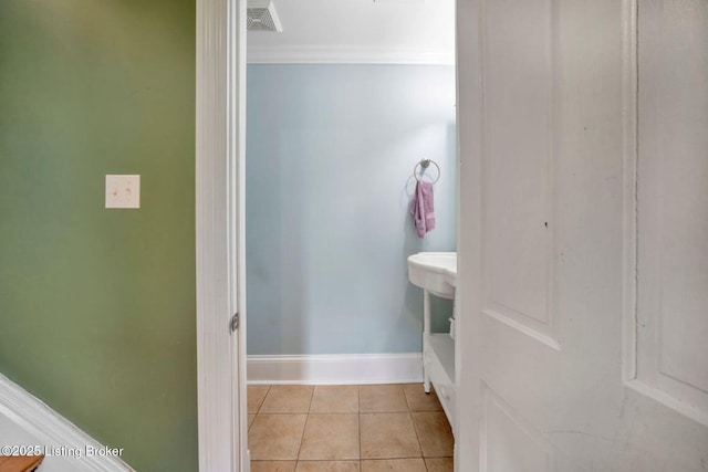 bathroom with crown molding, tile patterned floors, and baseboards
