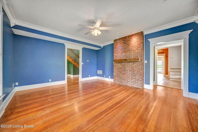 unfurnished living room featuring stairway, ceiling fan, hardwood / wood-style floors, crown molding, and baseboards