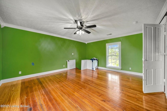 spare room featuring baseboards, wood-type flooring, ceiling fan, a textured ceiling, and ornamental molding