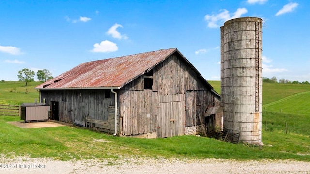 view of barn with a yard and a rural view