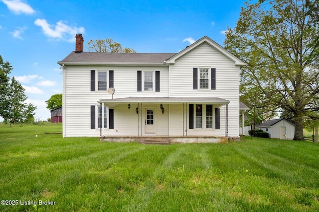 view of front of property featuring a chimney, a front lawn, and a porch