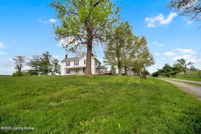 view of front of house featuring a chimney and a front lawn