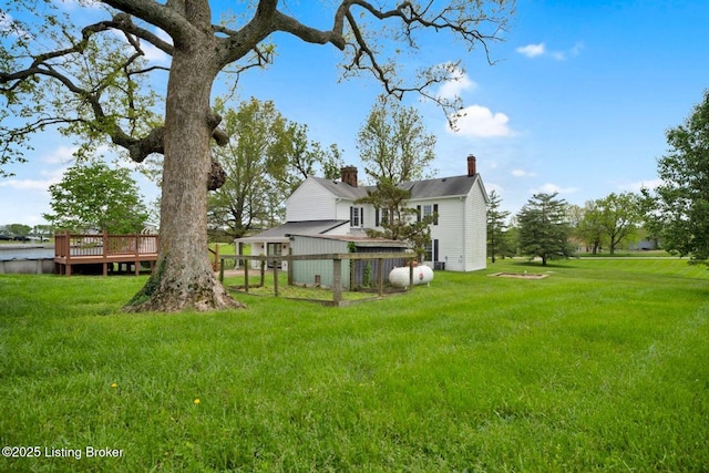 view of green lawn with a wooden deck