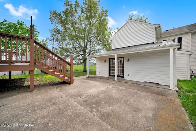 view of home's exterior with metal roof and a patio