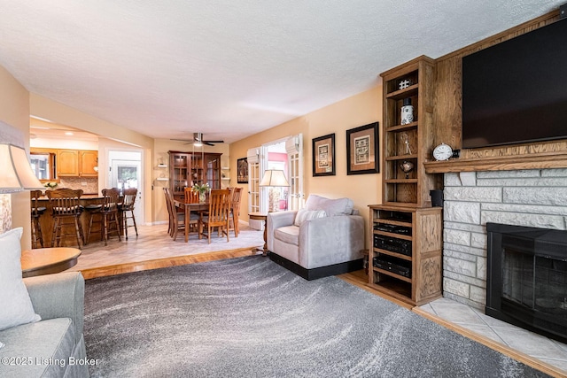8703 Waltlee Rd, Louisville, KY 40291 - living area featuring a ceiling fan, a fireplace, and a textured ceiling