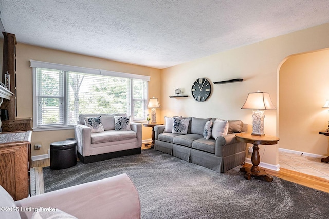 8703 Waltlee Rd, Louisville, KY 40291 - living area with a textured ceiling, baseboards, and arched walkways