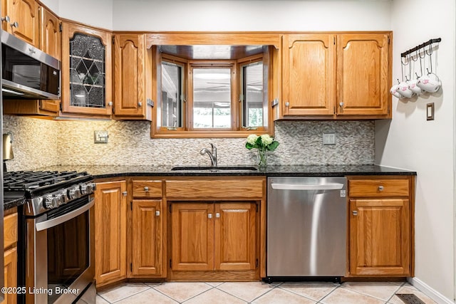 8703 Waltlee Rd, Louisville, KY 40291 - kitchen with stainless steel appliances, a sink, brown cabinetry, and light tile patterned flooring